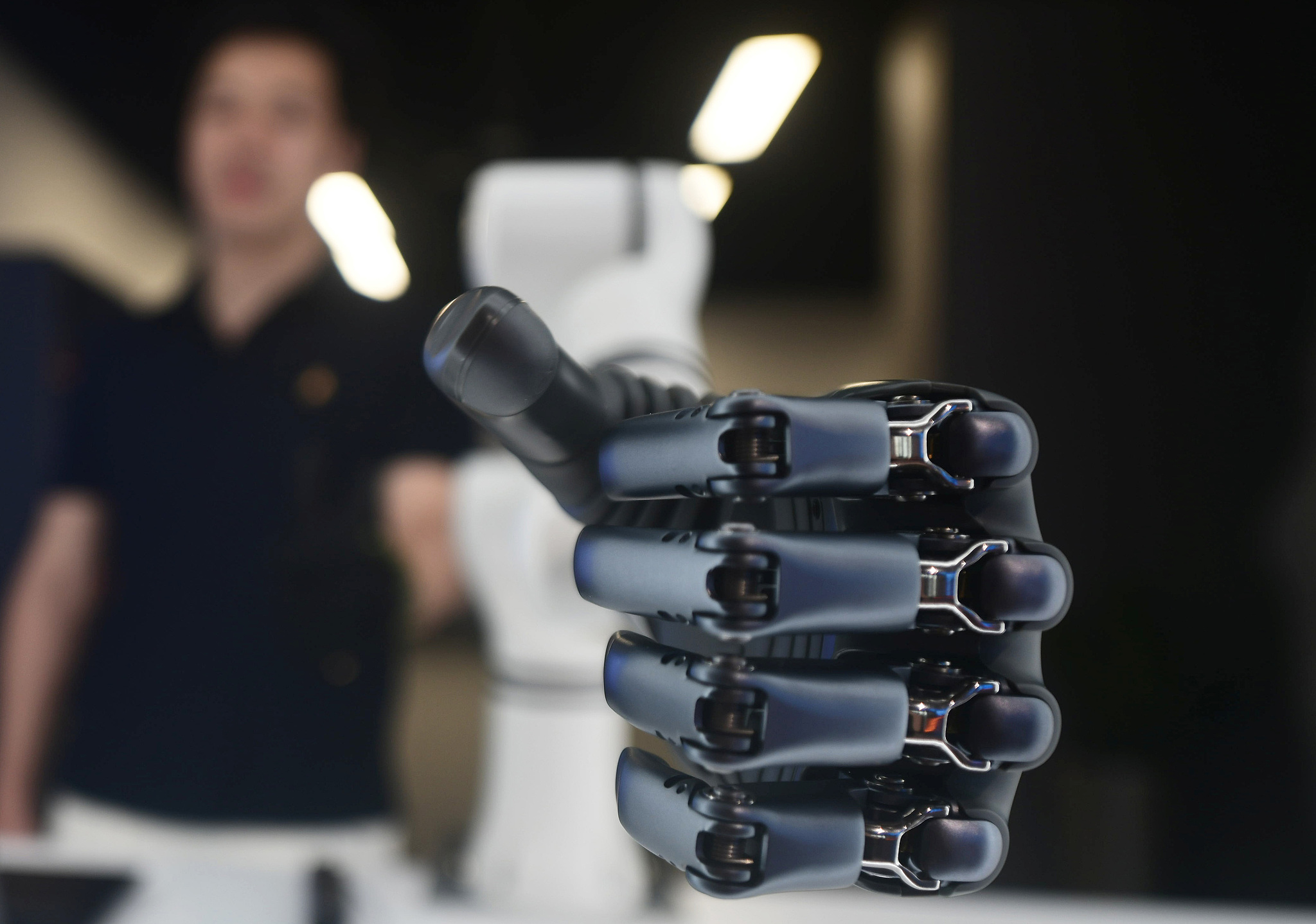 A BrainCo employee demonstrates a brain-computer interface bionic hand at Wensan Digital Life Block in Hangzhou, east China's Zhejiang Province, May 4, 2025. /VCG