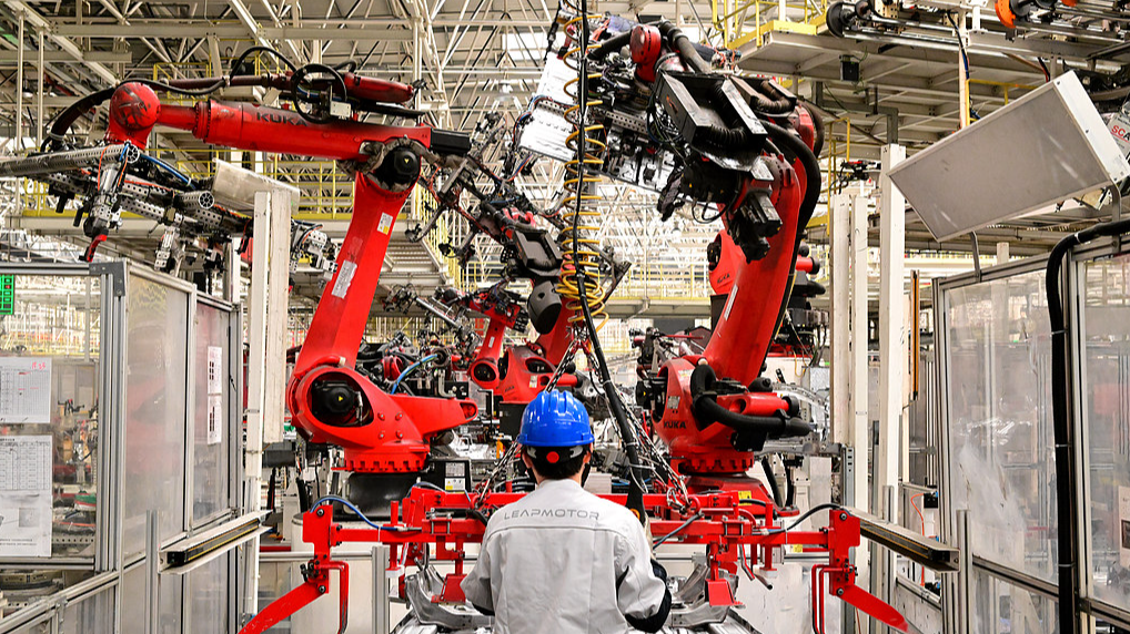 A worker assembles components on an automated new energy vehicle production line in east China's Zhejiang Province, May 13, 2025. /VCG